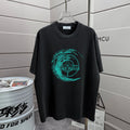 Stone Island Spring–Summer 2026 T-Shirt — 320gsm Washed Distressed Cotton, Teal Swirl Brushstroke Compass Rose Print